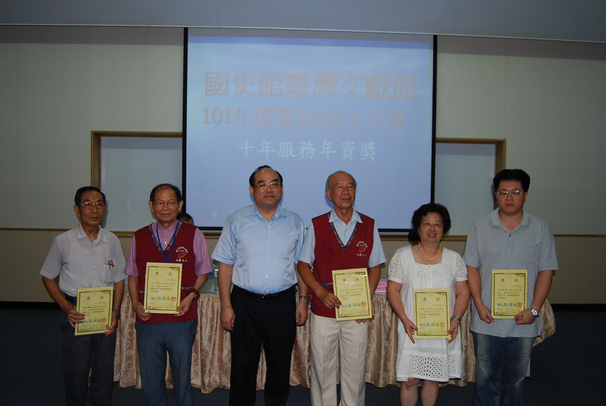 本館張館長鴻銘(左3)頒發服務滿10年年資獎予志工們並合影留念