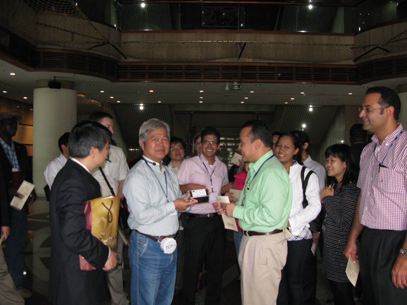 本館志工陳永裕老師親切地為來賓導覽展示文物(左2)，參訪來賓致贈禮物以表感謝。