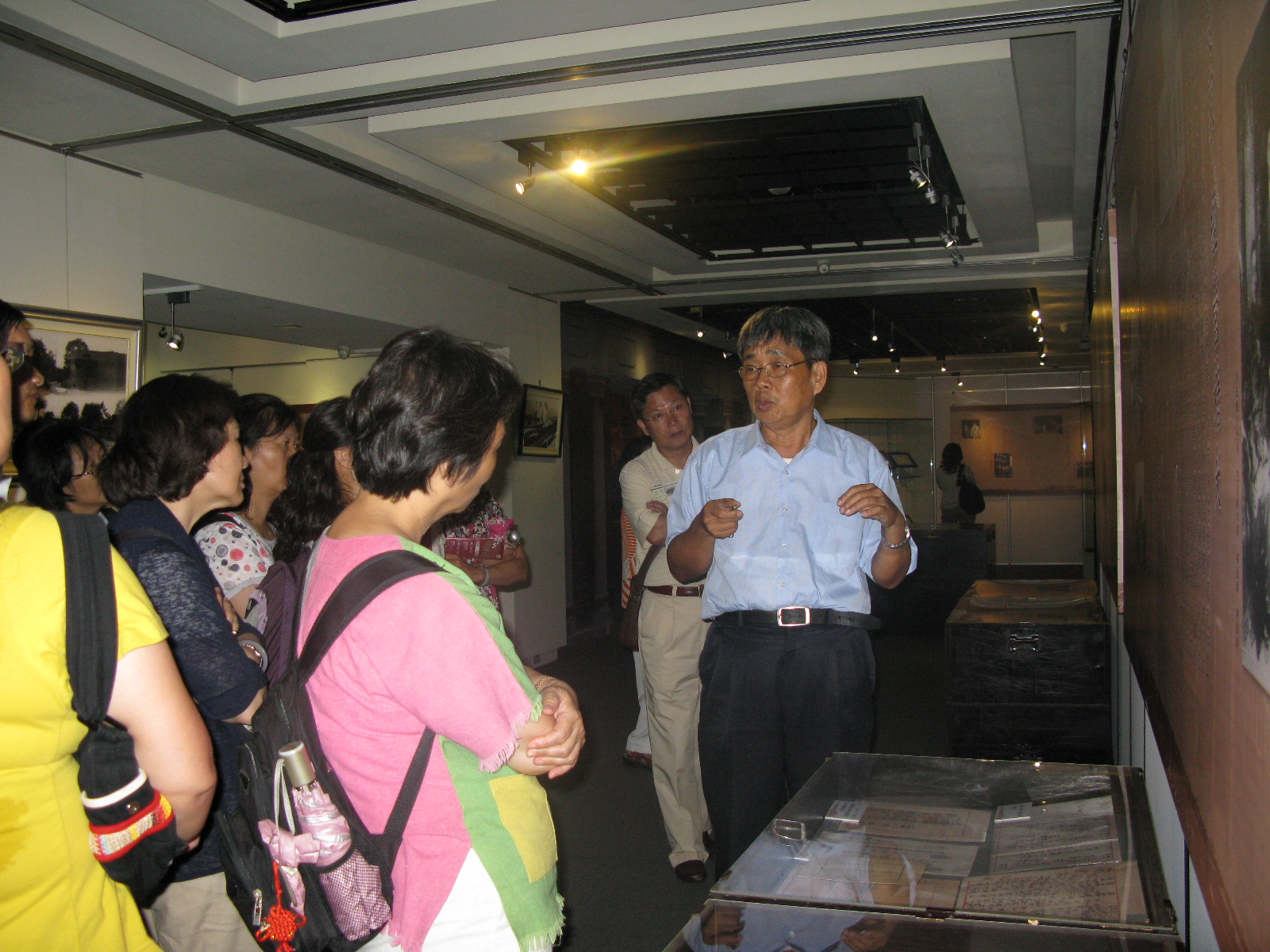 本館林研究員文龍(右1)為參訪者解說臺灣五大家族特展檔案及史料