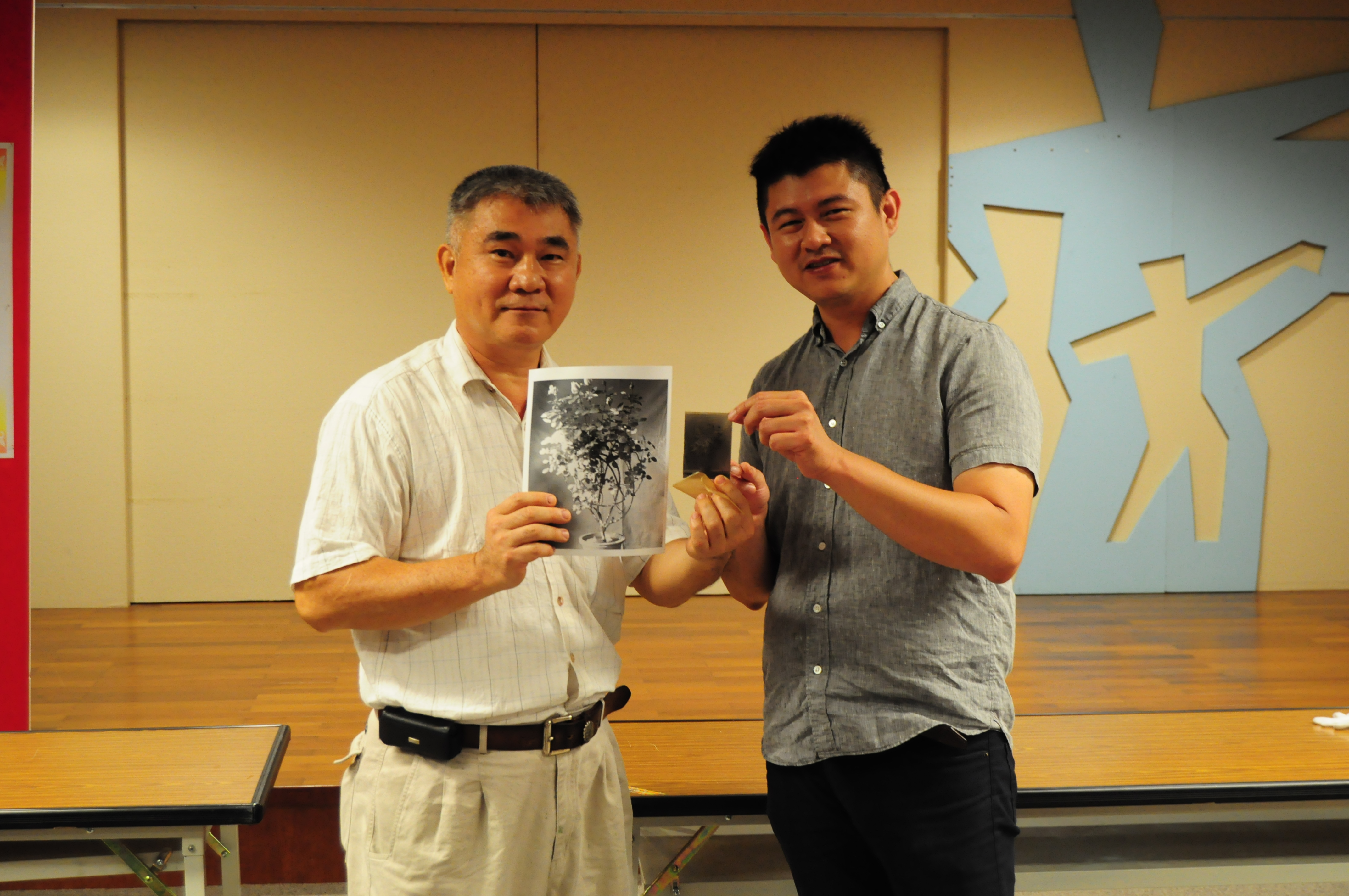 合辦單位臺中縣文化推廣協會郭理事長双富（左）致贈曾啟峰老師（右）玻璃底片