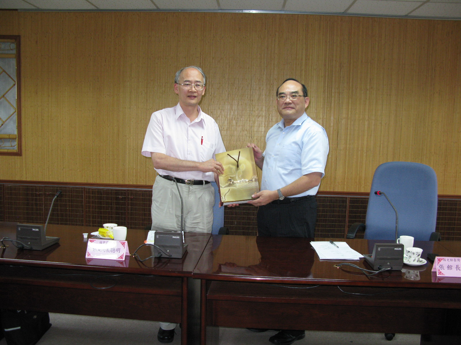 本館張館長鴻銘（右）與檔案管理局張副局長聰明（左）互相交換紀念品