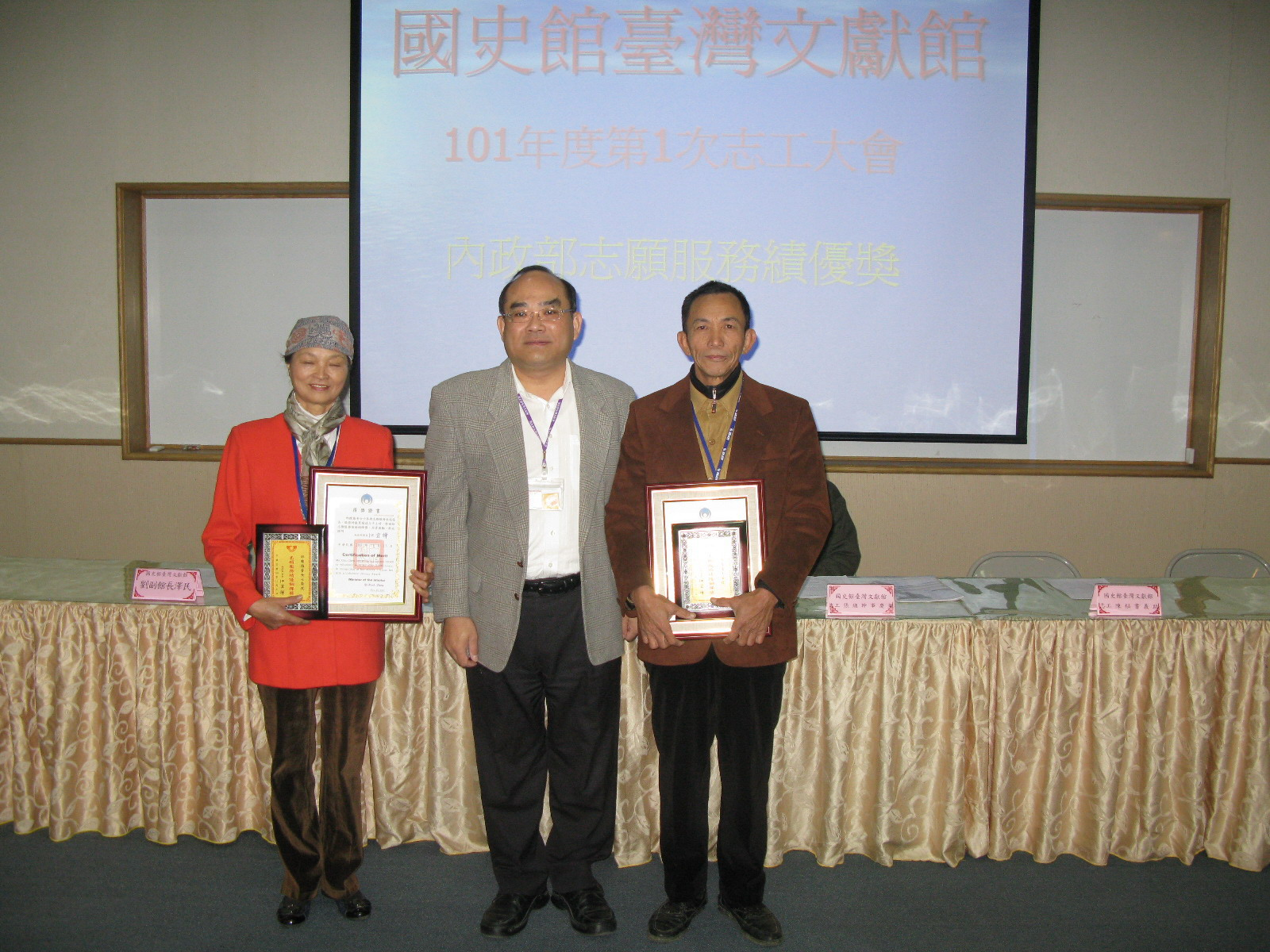本館張館長鴻銘(中)轉頒內政部志願服務績優銅牌獎予本館志工邱陳梅香女士(左1)、孫正春先生(右1)