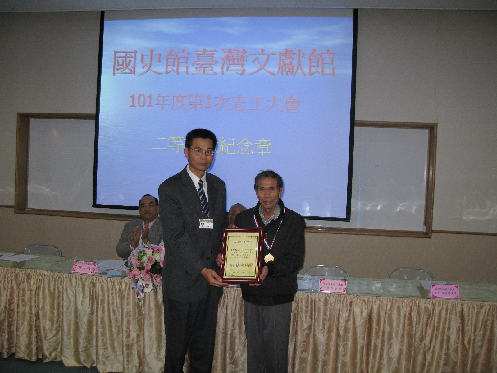 本館劉副館長澤民(左)頒發二等文獻志工紀念章及獎牌予本館志工黃季文先生(右)