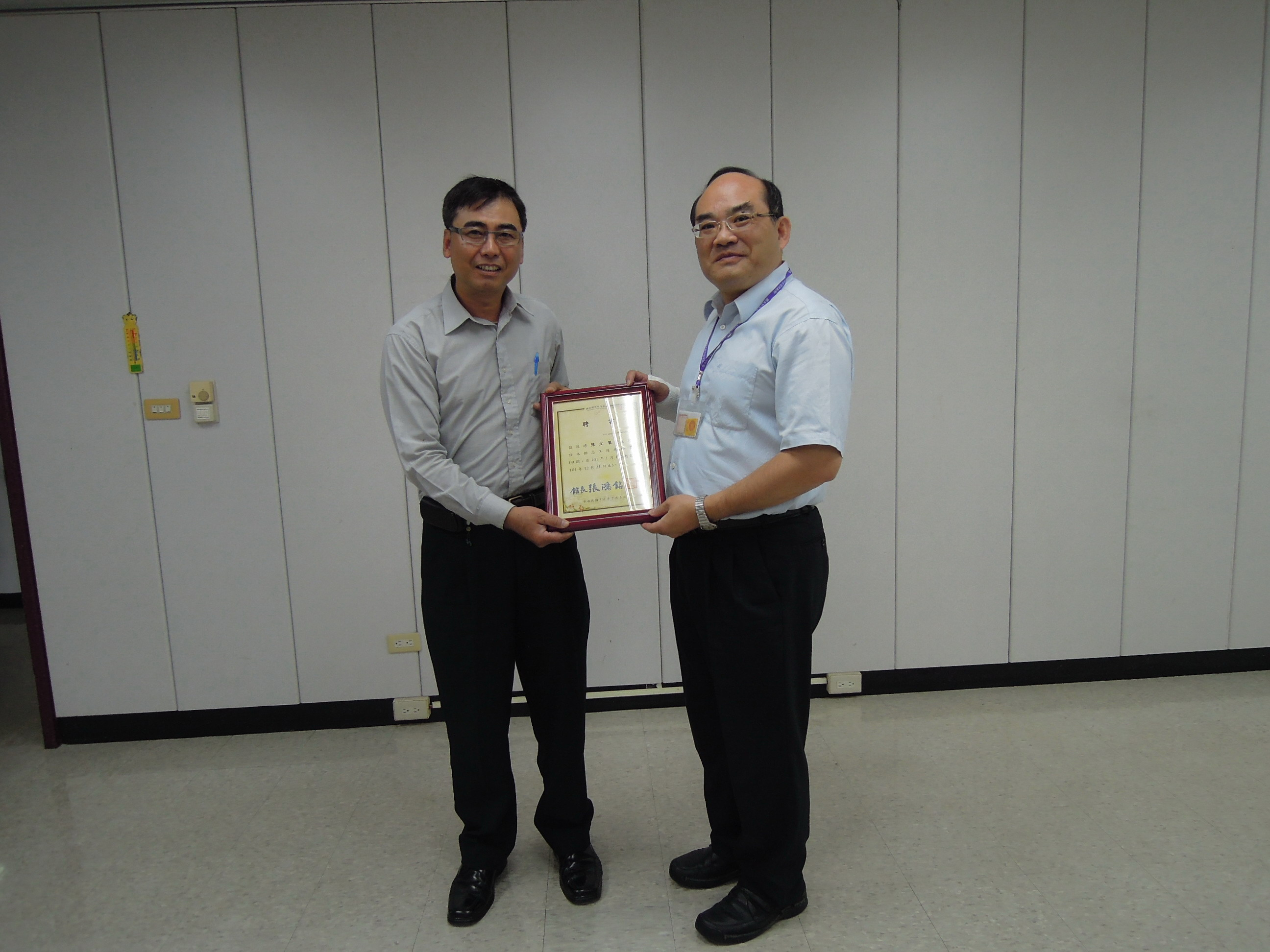 本館張館鴻銘(右)頒發志工幹部聘書予本館志工隊陳總幹事文筆