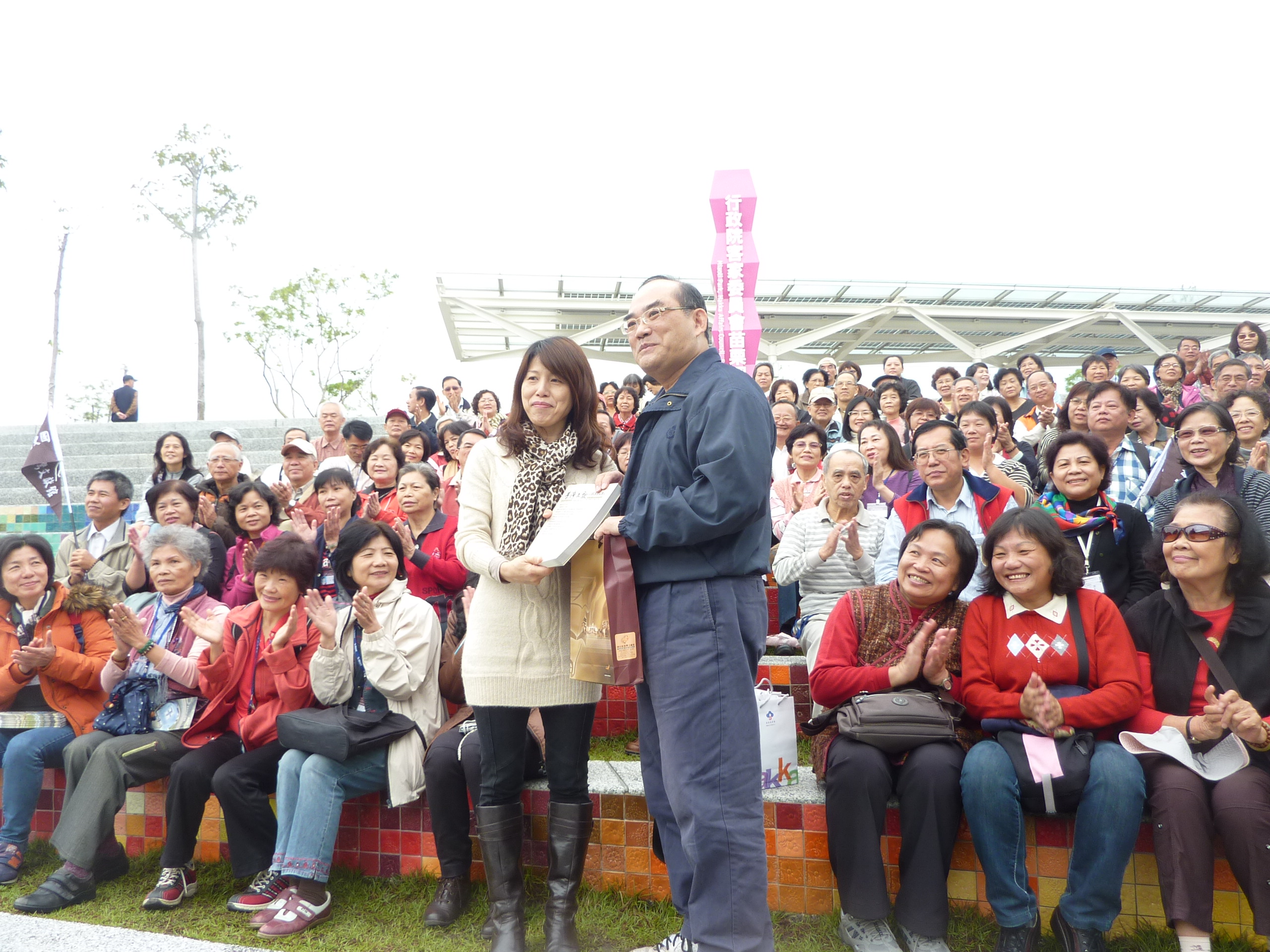 苗栗客家文化園區文物典藏組呂組長姿玲(立左)與本館張館長鴻銘（立右）交換紀念品