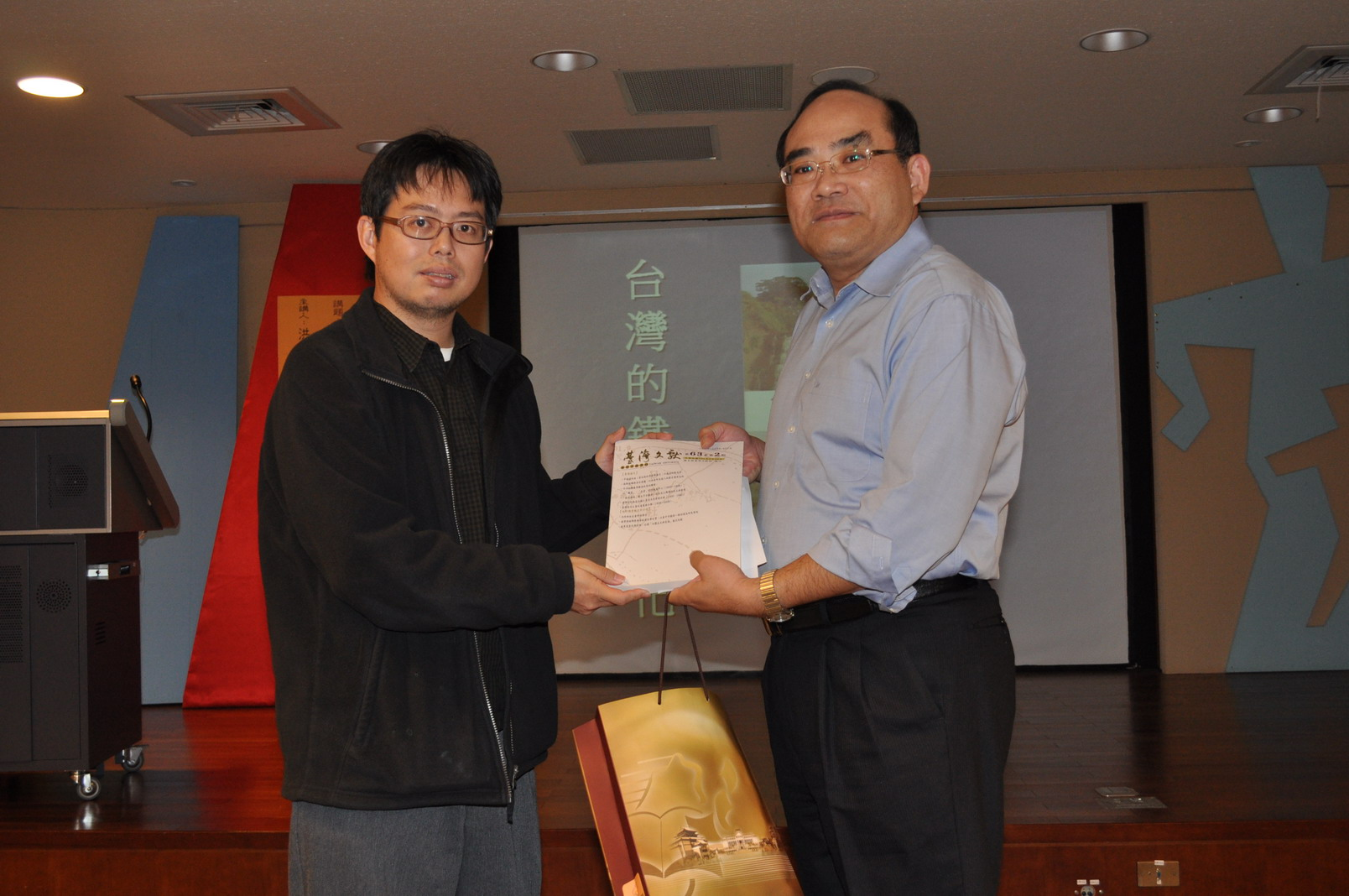 本館張館長鴻銘（右）致送洪副教授致文（左）出版品