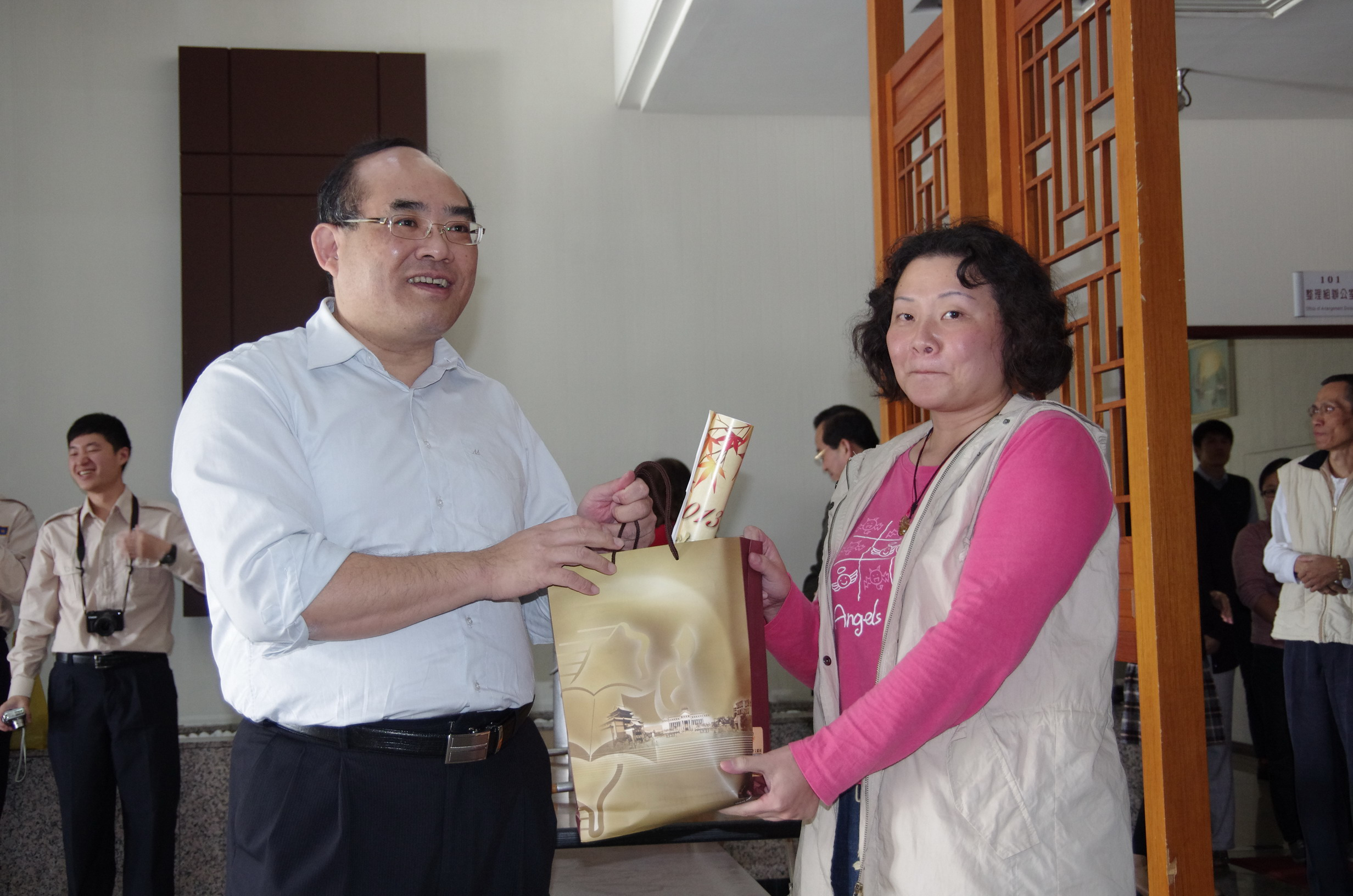 張館長鴻銘（左）致送研究助理邱欣怡小姐（右）等8位紀念品