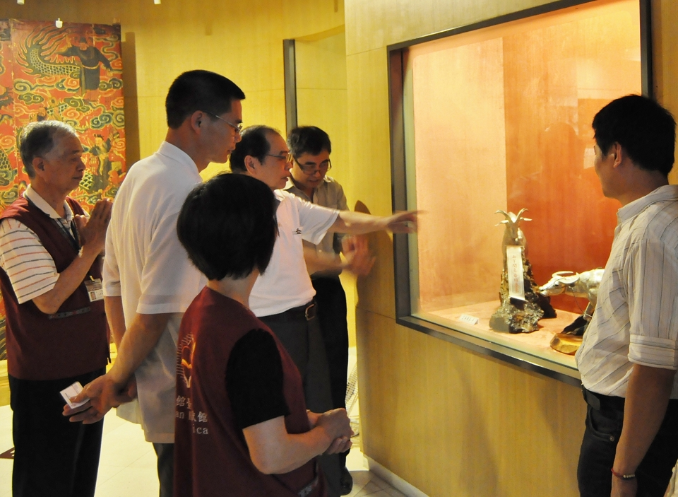 陳萬能先生（伸手指展件者）介紹其錫藝作品之創作理念