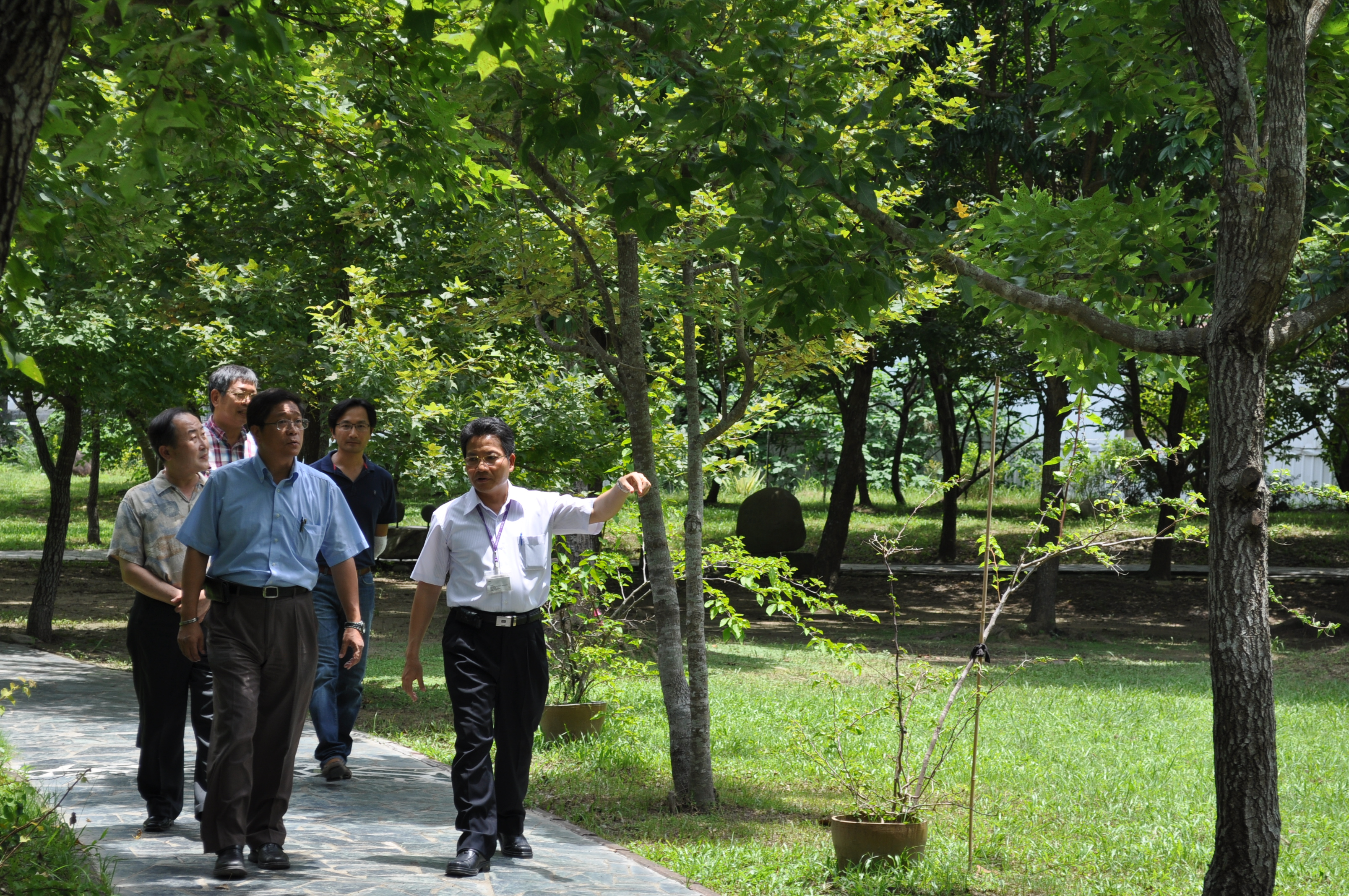 本館整理組林明洲組長(前排右)向國立臺中女中戴旭璋校長(前排左)等人解說文獻步道及園區景觀