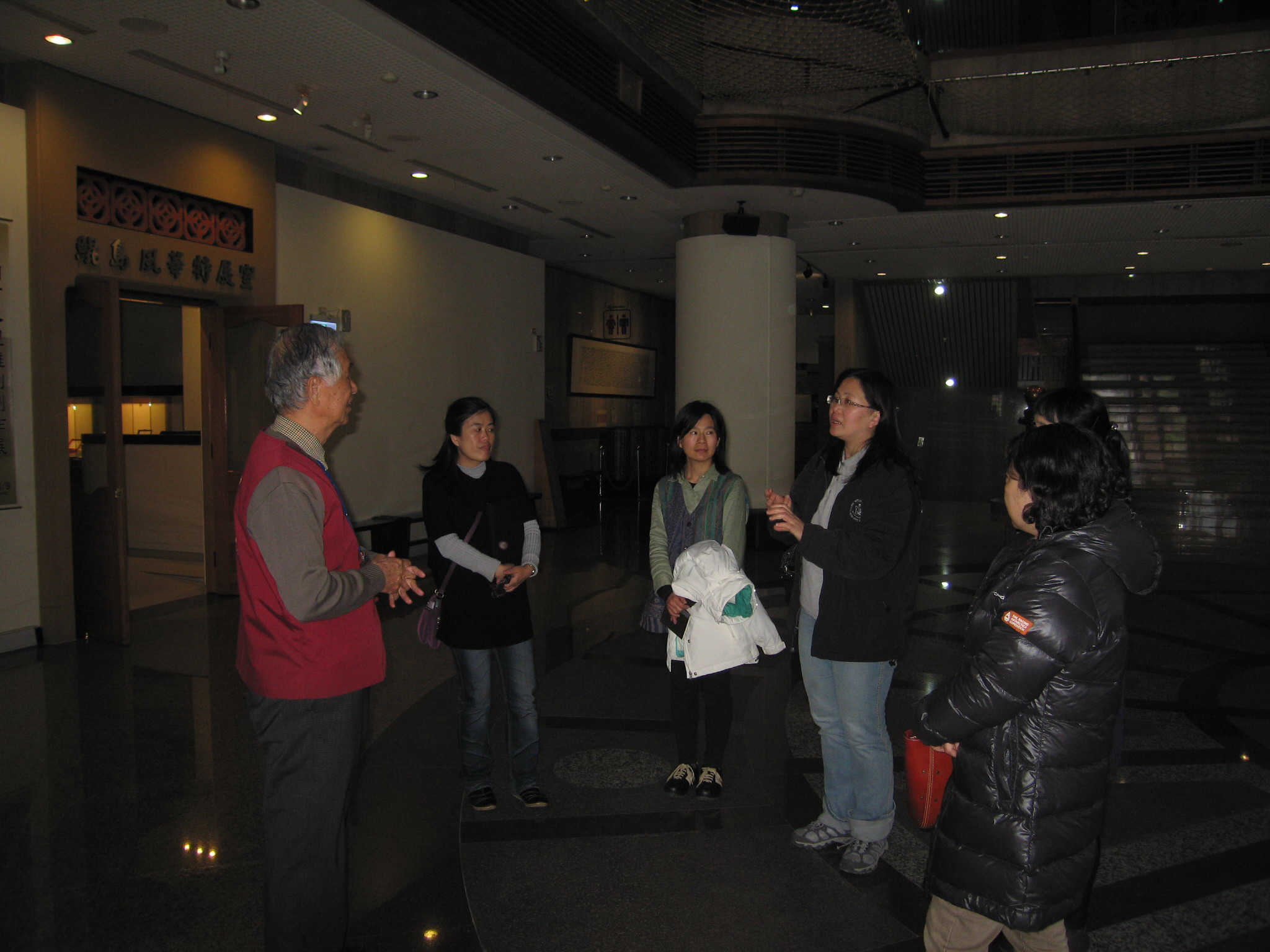 圖3.本館志工張慶龍先生(左1)親切地為來賓導覽展示文物