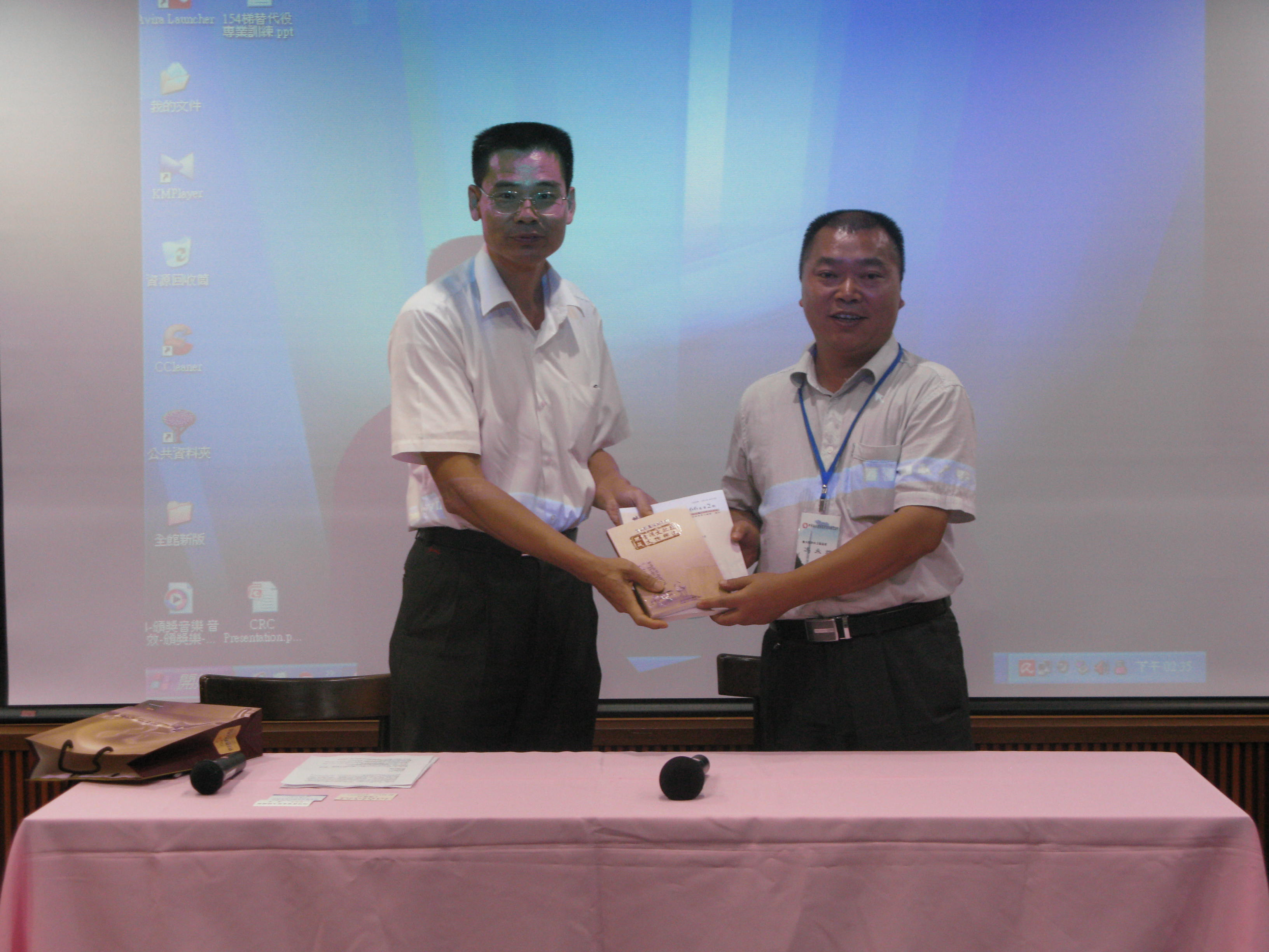 圖二、本館劉澤民副館長（左）與參訪團交流出版品