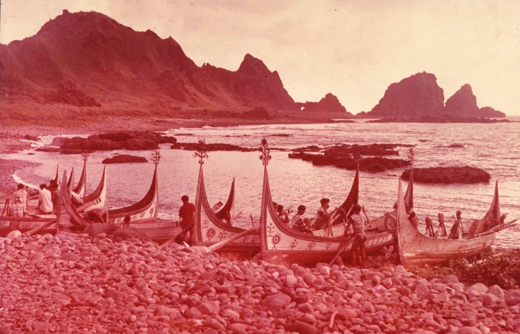 圖2：畫面中可見東清灣美麗的圓弧，以及岸邊雅美（達悟）族男人整備拼板舟出海的景象，遠望可看到著名地景「情人洞」。