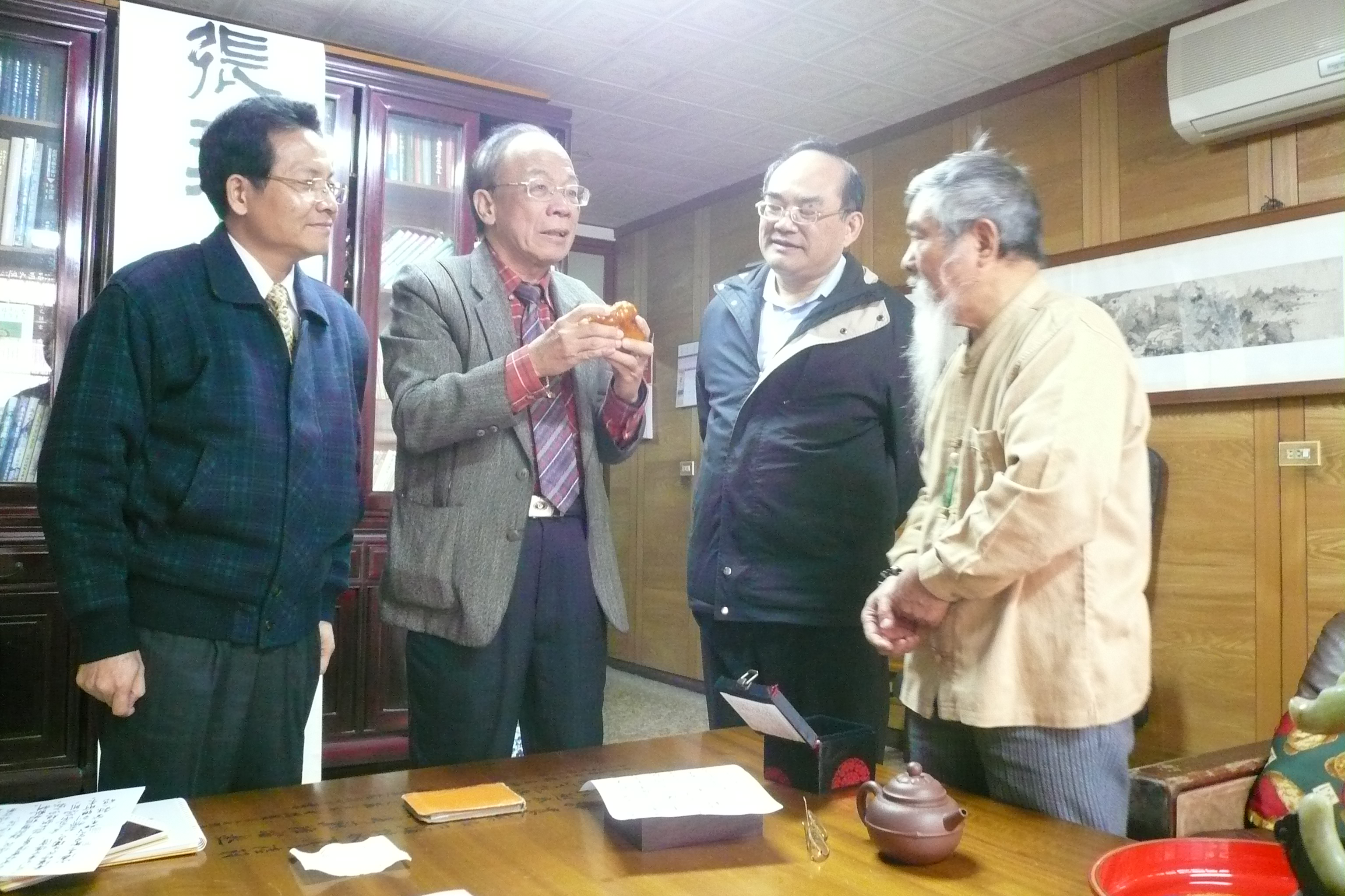 圖三.黃智茂老師（右）向張鴻銘館長（右二）及簡榮聰前主委（左二）解說收藏珍貴文物