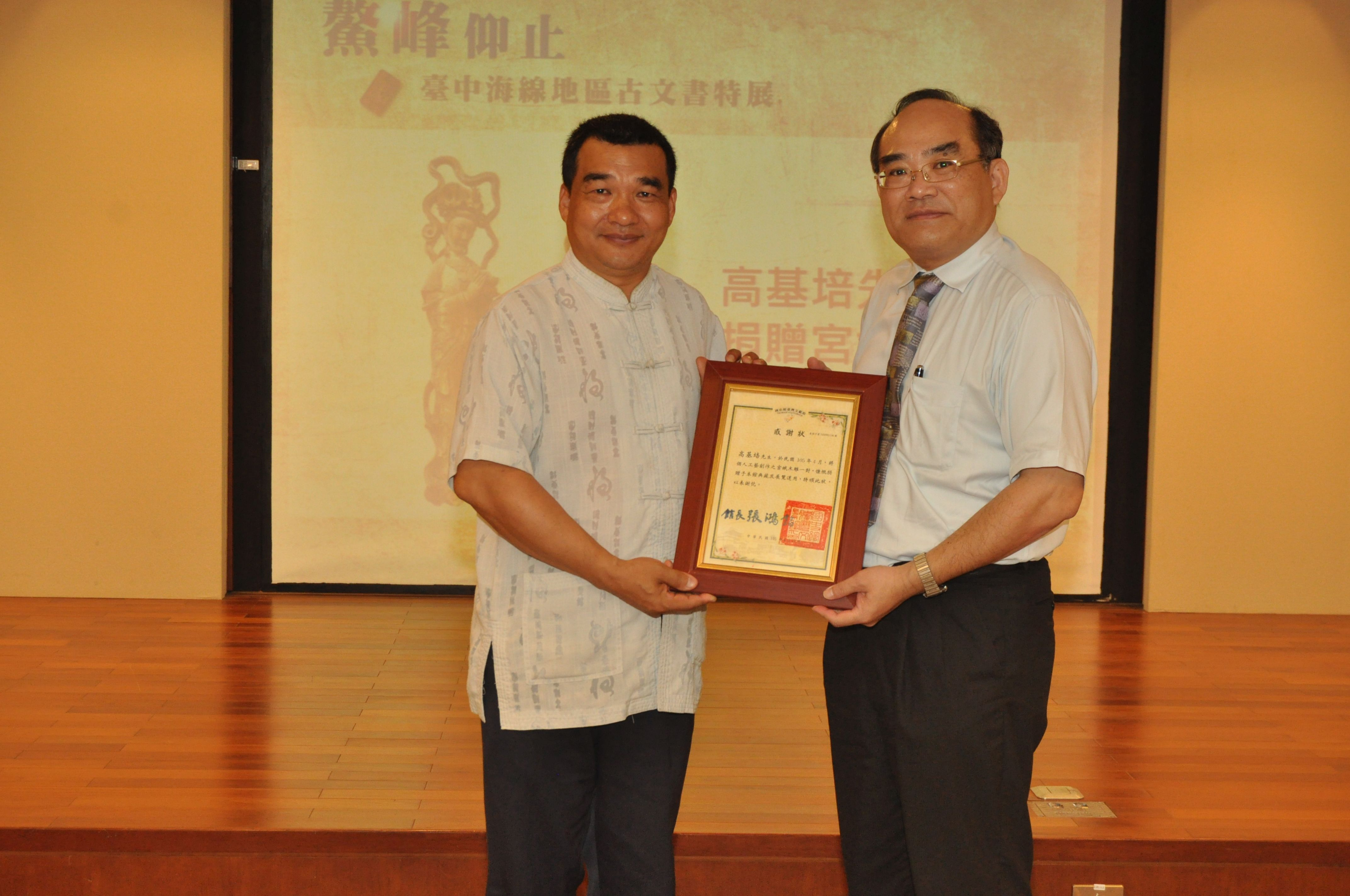 圖12：張鴻銘館長(右)致贈感謝狀予文物捐贈人高基培先生