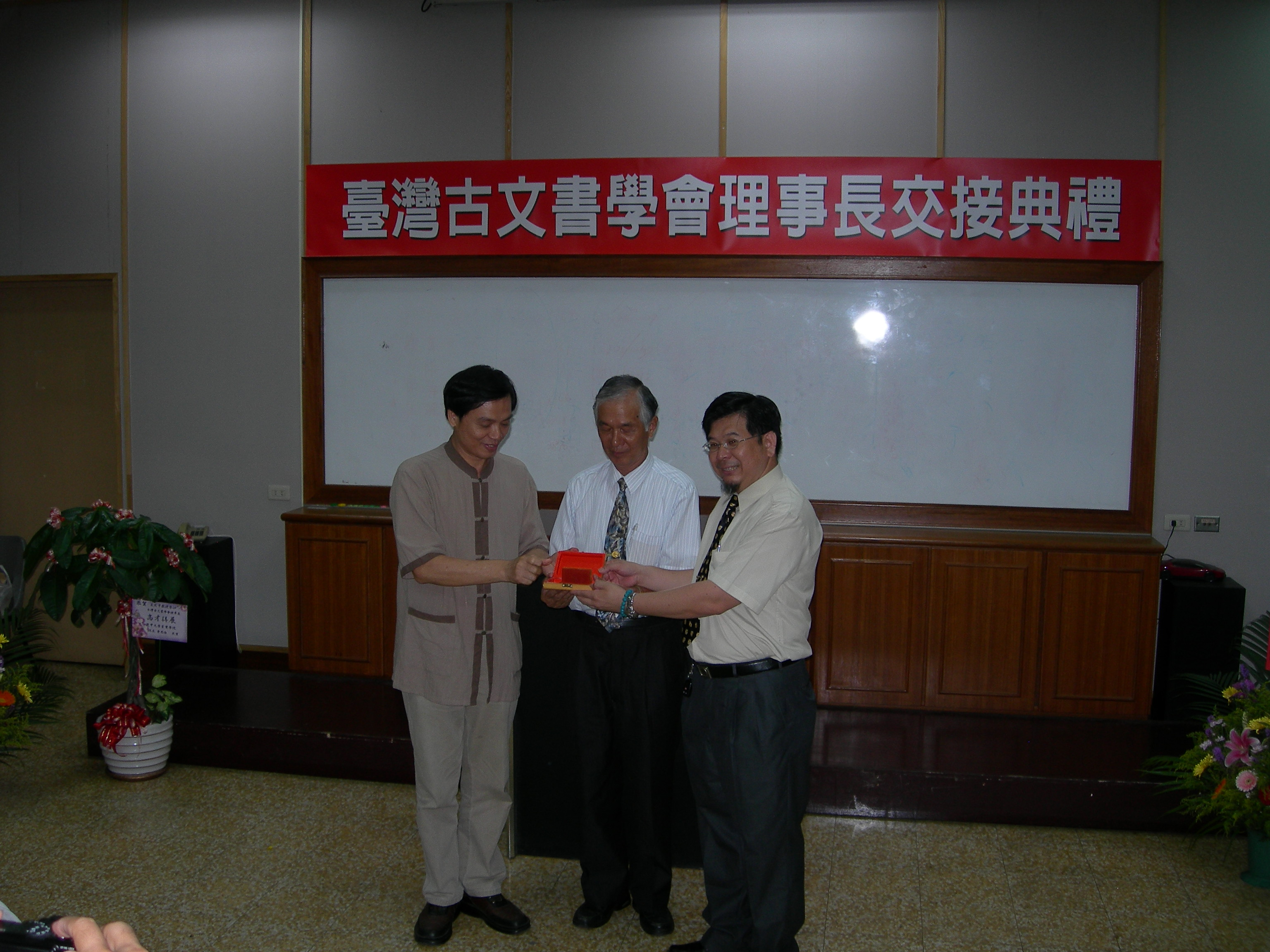 圖2：新任（王志宇右）舊任（梁志忠左）理事長由常務監事張慶龍（中）監交。