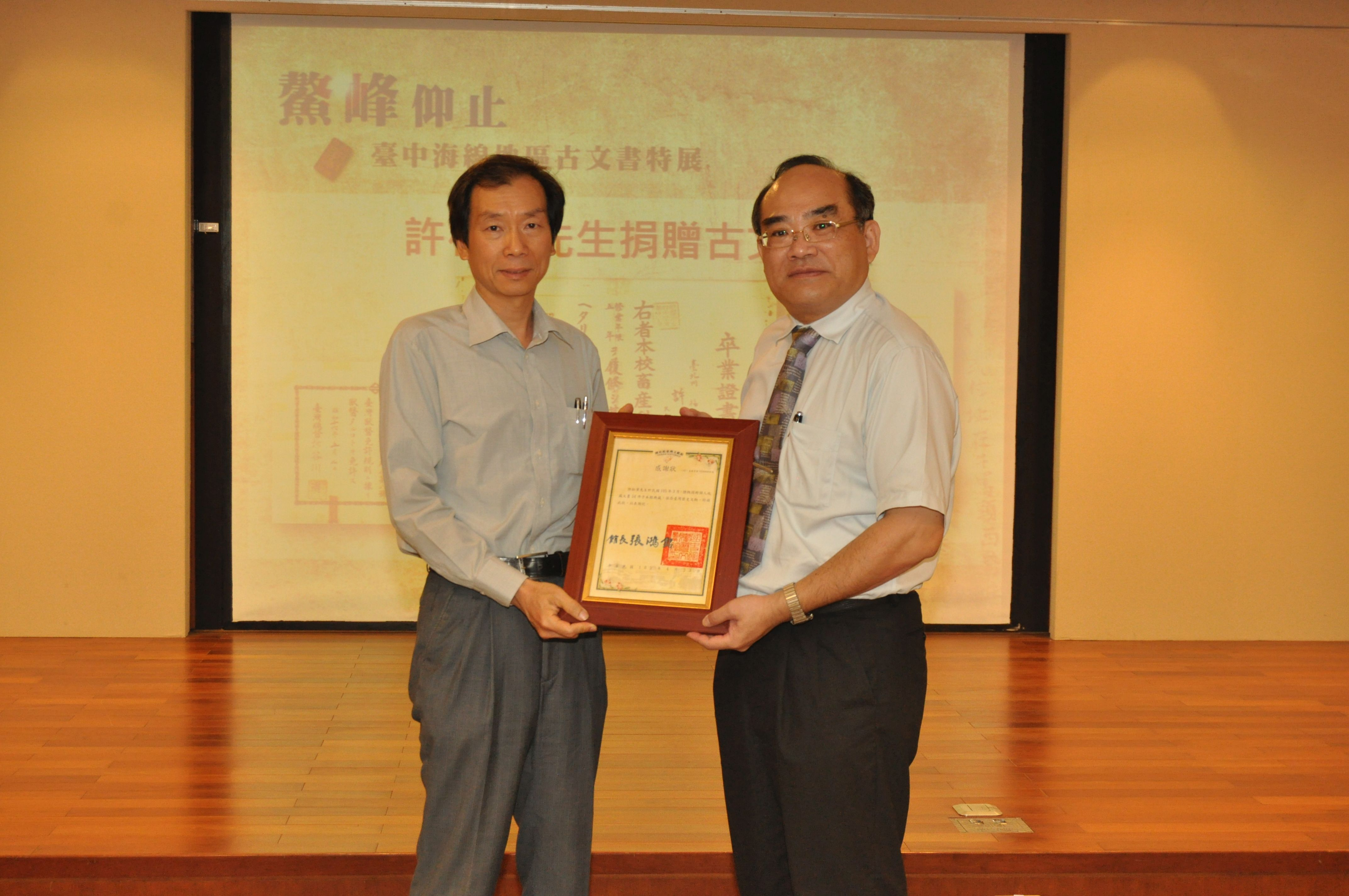 圖13：張鴻銘館長(右)致贈感謝狀予文物捐贈人許松章先生，由其公子許正宗先生代表接受