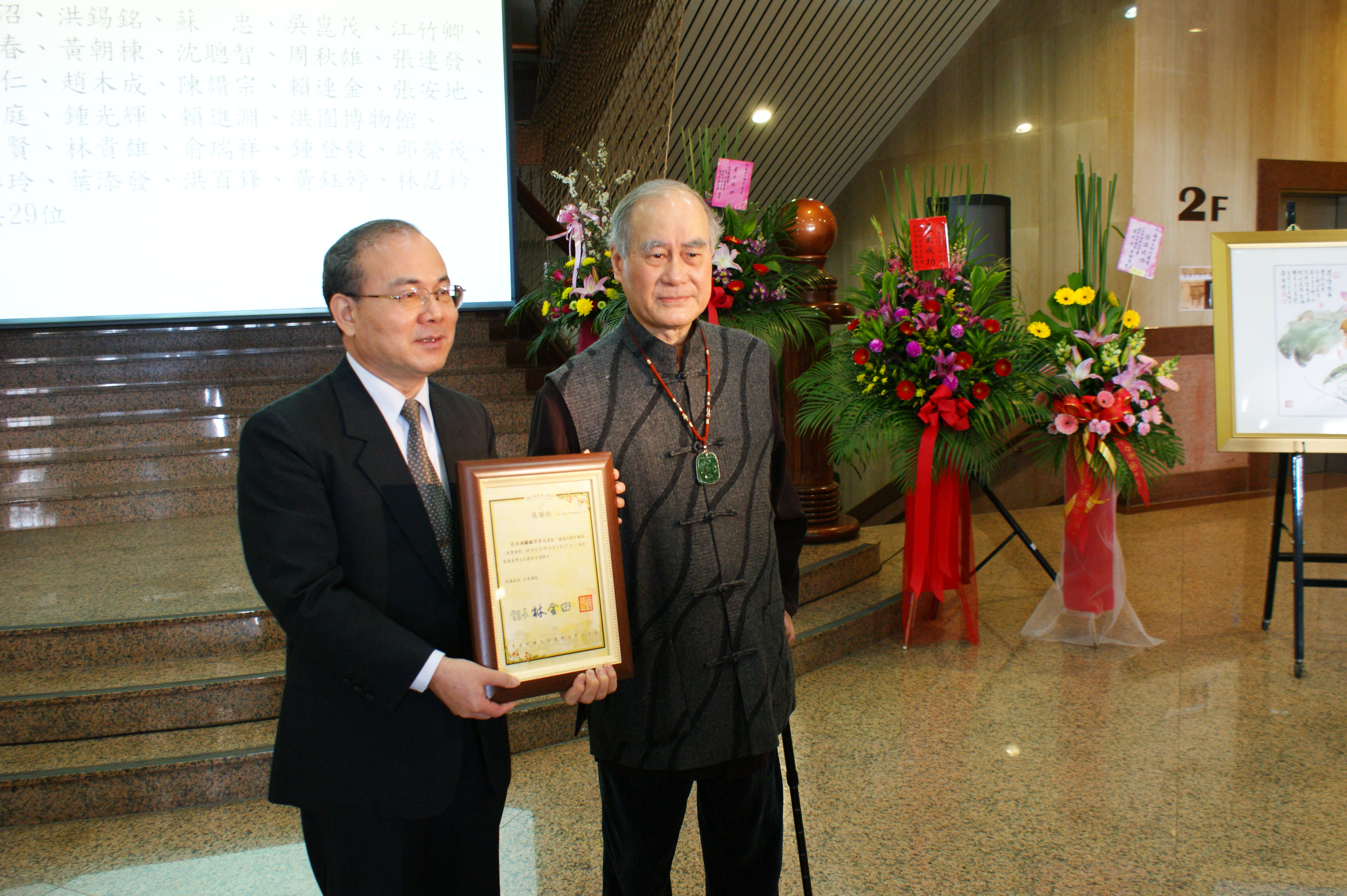 瀛海文物珍藏展　林館長金田（左）贈感謝狀予臺灣省文物藝術收藏學會洪理事長錫銘（右）