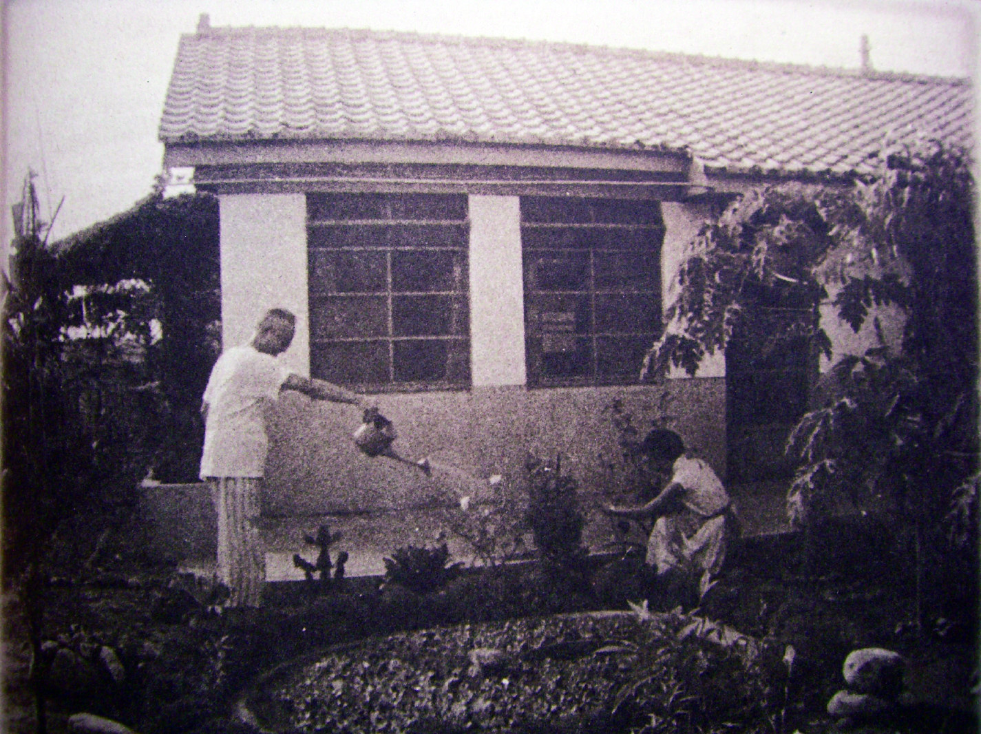 夫妻在優雅房舍前灌溉一方心靈田畝。作者翻拍