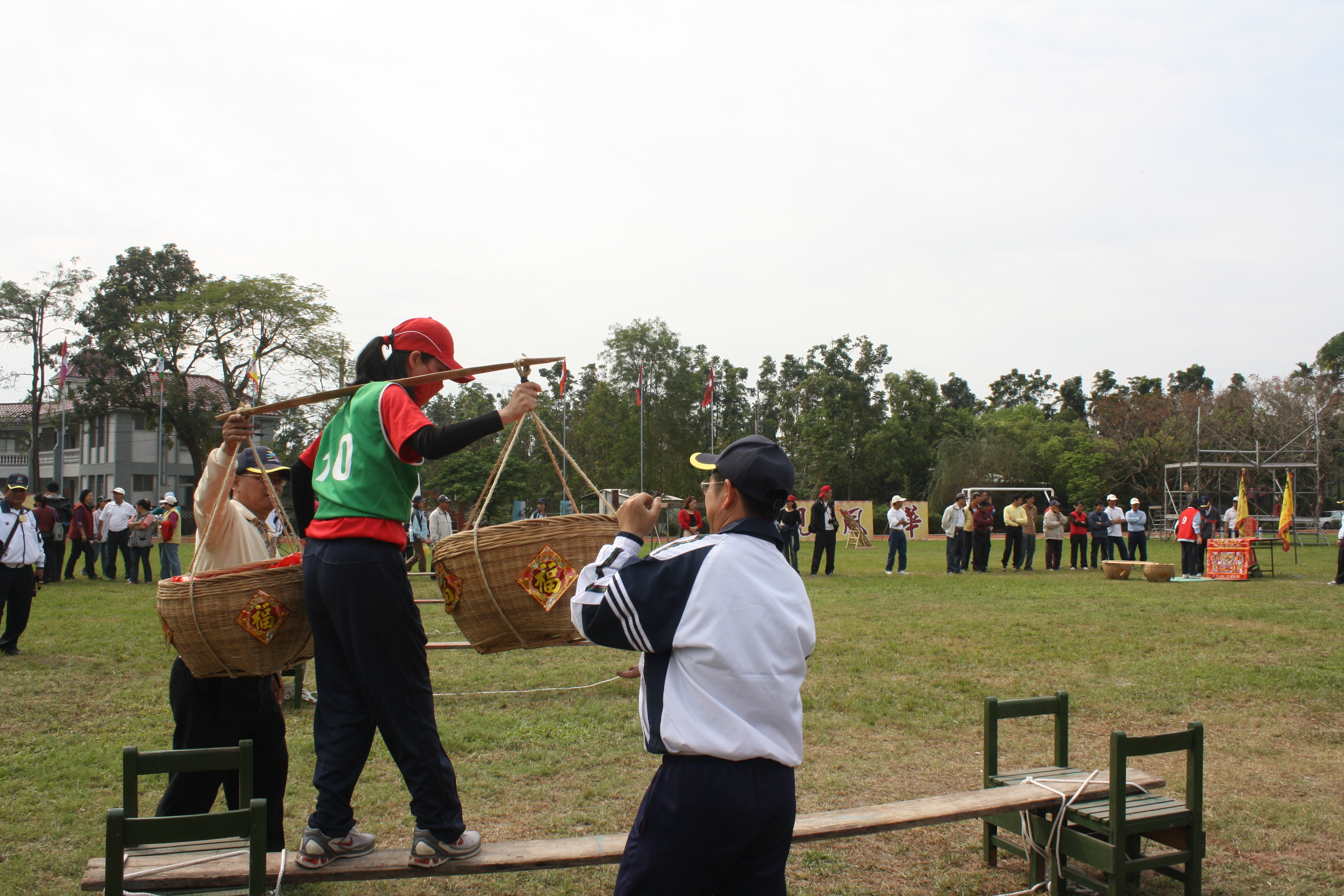 神桌擲筊：挑飯擔走過獨木橋，在神桌前擲3個聖筊，再挑擔回去交給下一棒