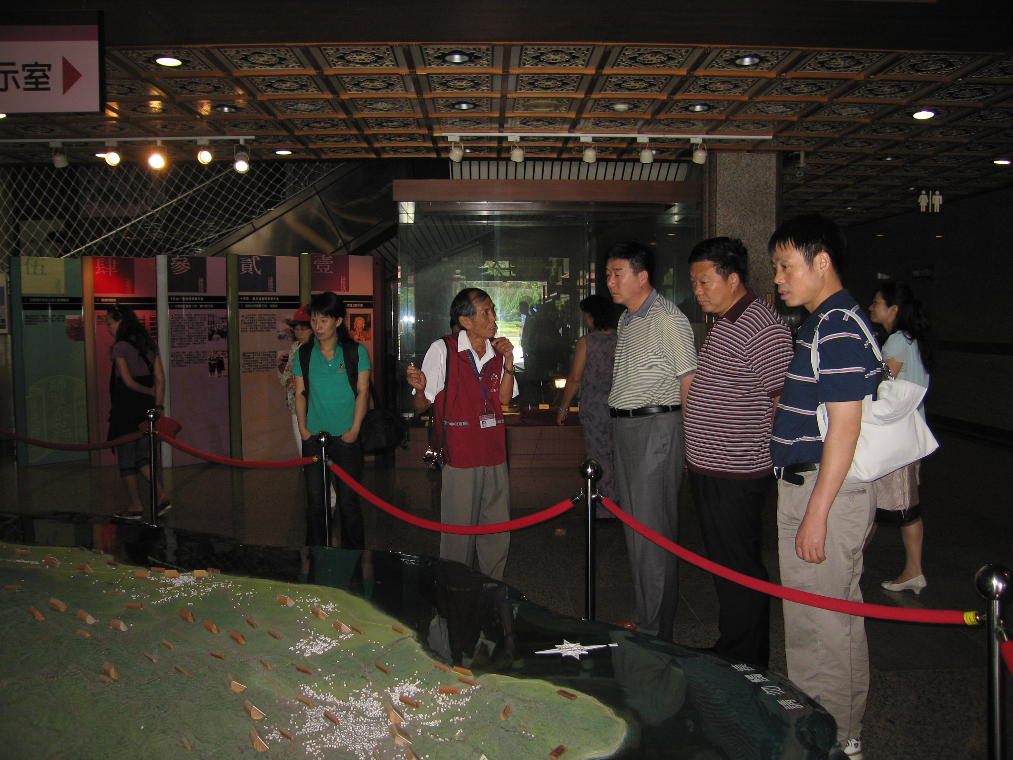 本館志工黃季文老師為參訪者導覽解說史蹟大樓展示文物