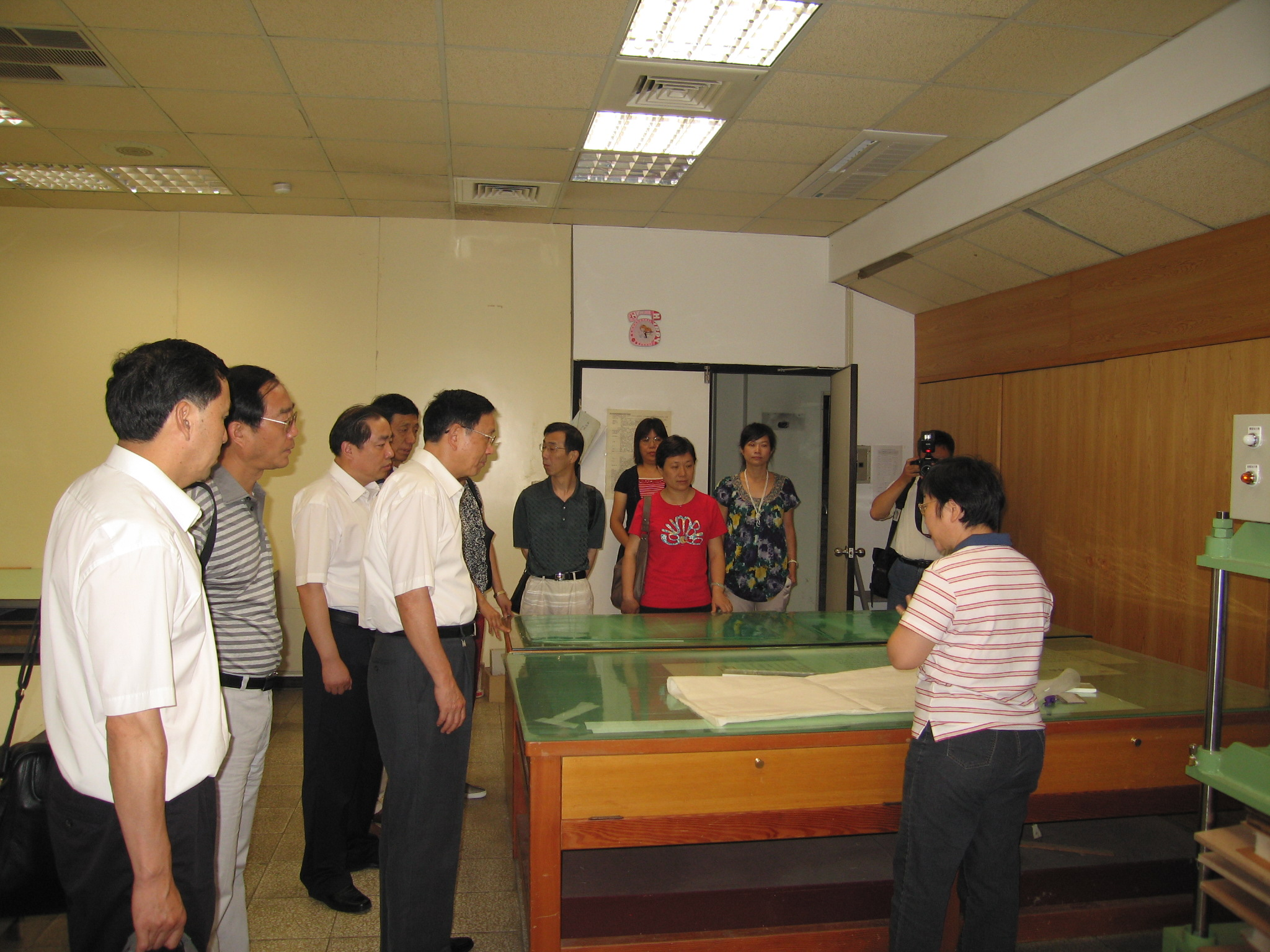 本館林春綢小姐(右)為參訪團解說檔案裱褙及維修流程