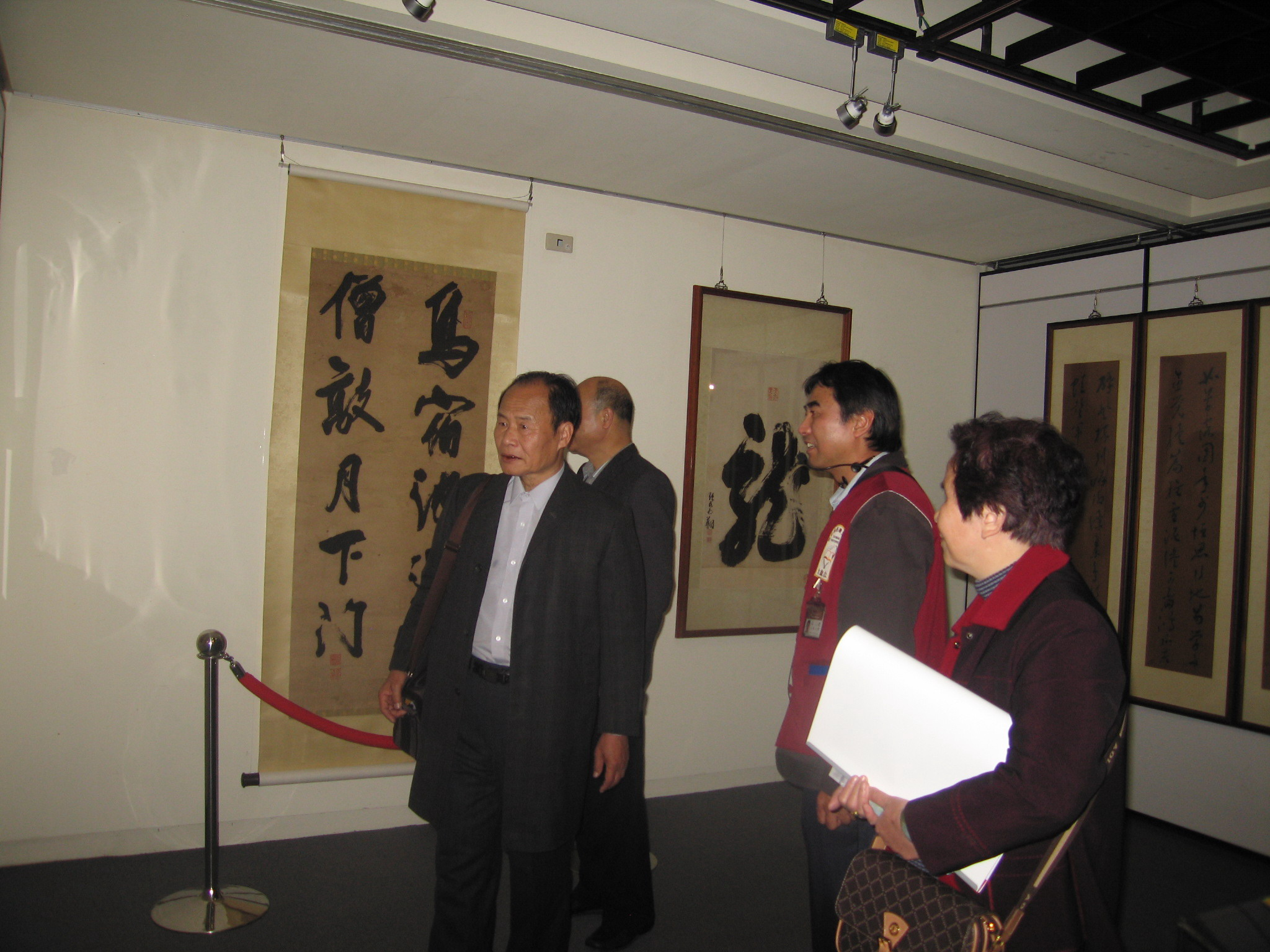 本館志工陳文筆老師(右2)親切的為參訪者導覽早期書畫展示