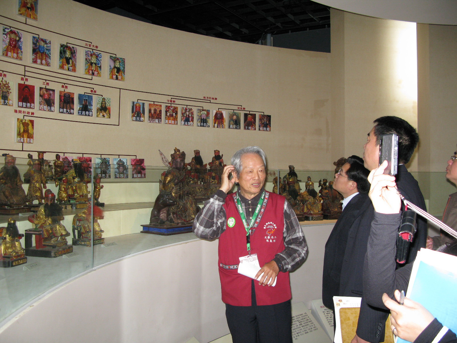 本館志工陳義助(左1)老師親切地為來賓導覽展示文物