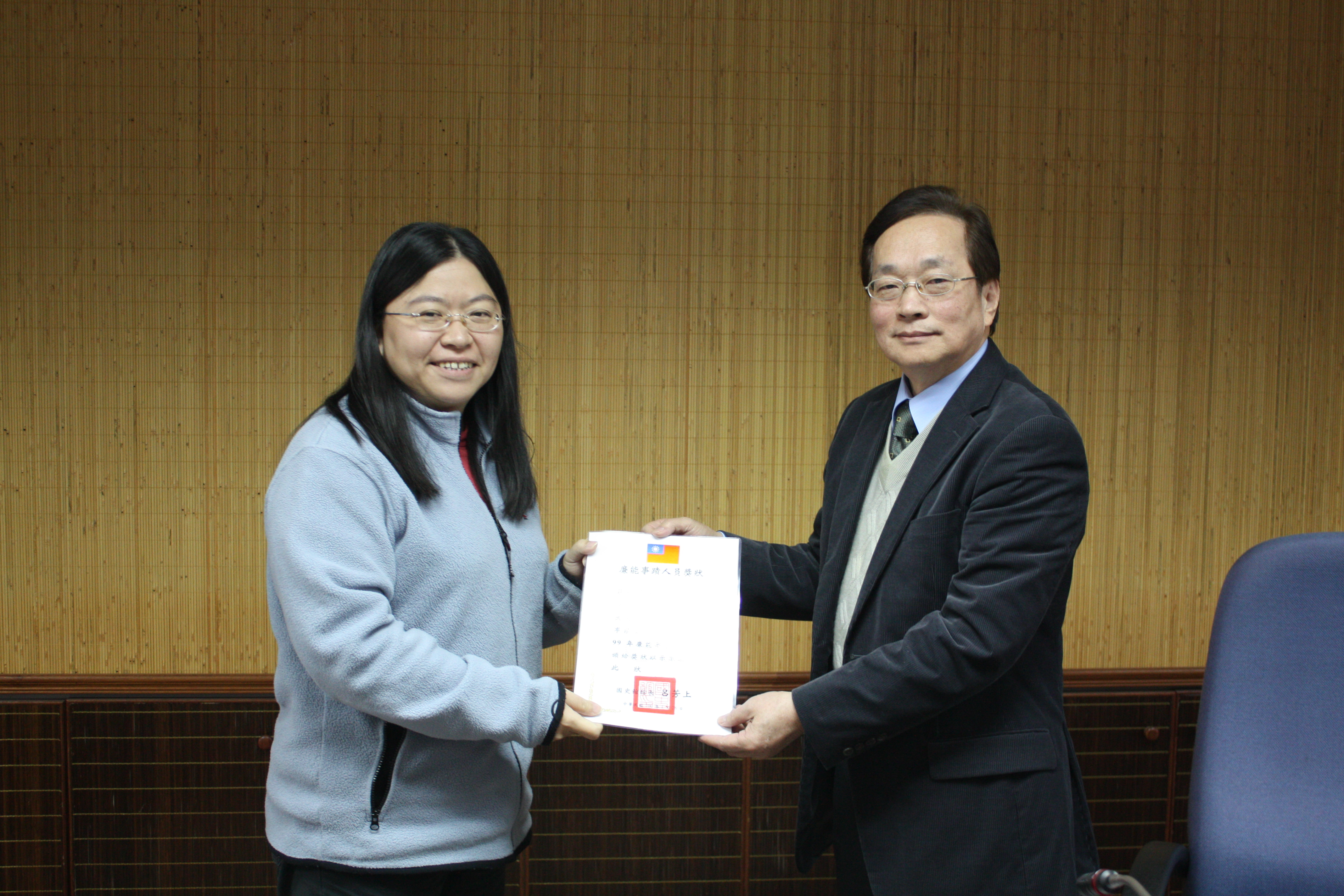 國史館呂館長（左）頒發廉能人員獎狀予本館蔡科員佩端（右）